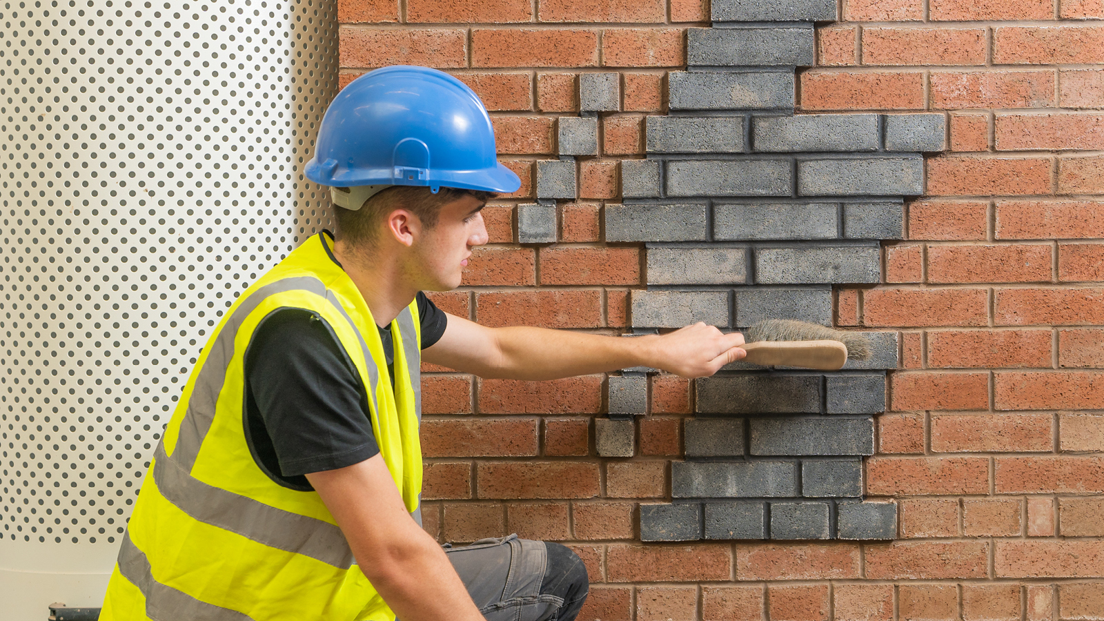 A construction student working on a wall.
