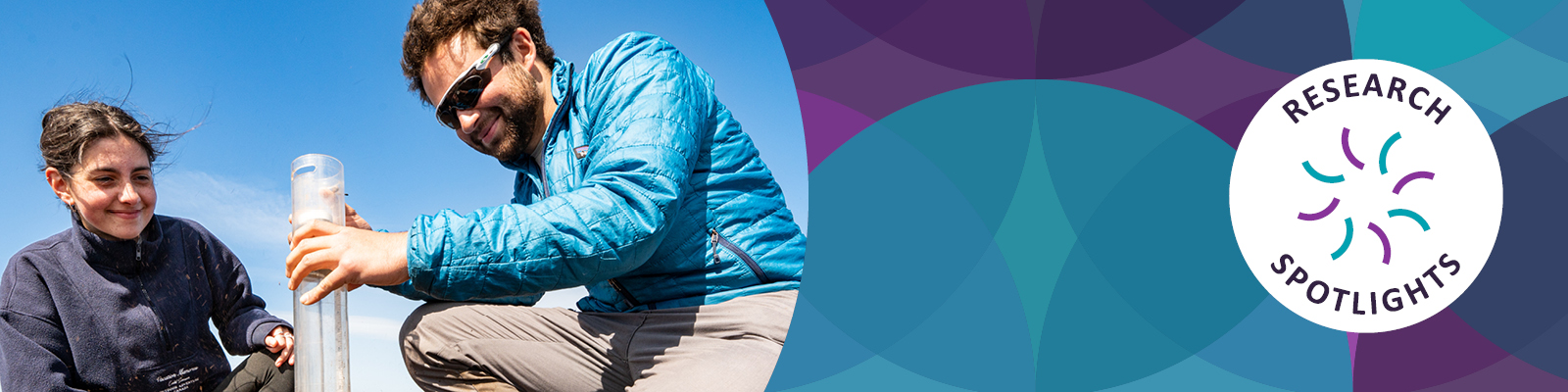 A young researcher in a blue jacket examines a clear tube outdoors, while a colleague assists in their scientific investigation. On the right, a colourful abstract background with the "Research Spotlights." logo.