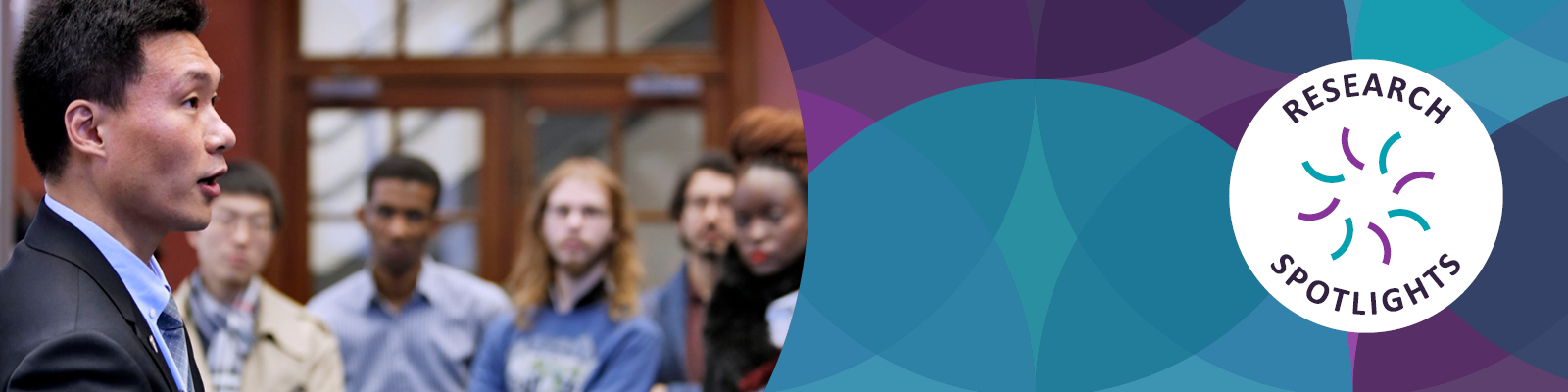 A group of individuals attentively listens to a speaker in a formal setting, with a logo for "Research Spotlights" in the corner.