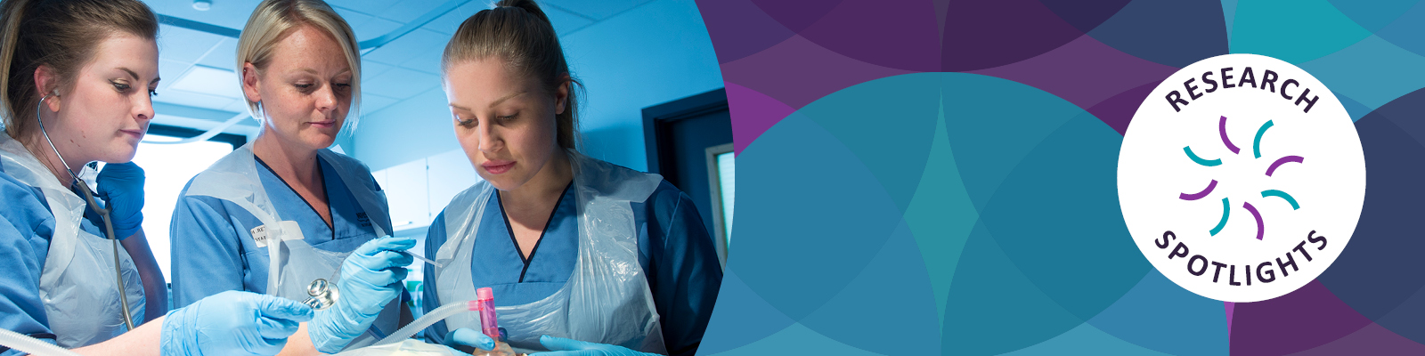 Three healthcare professionals in blue scrubs and gloves are collaborating on a medical procedure in a bright clinical setting. The logo for "Research Spotlights" is in the right corner.