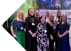 Group photo of the clean energy team in front of SPEERI banner.